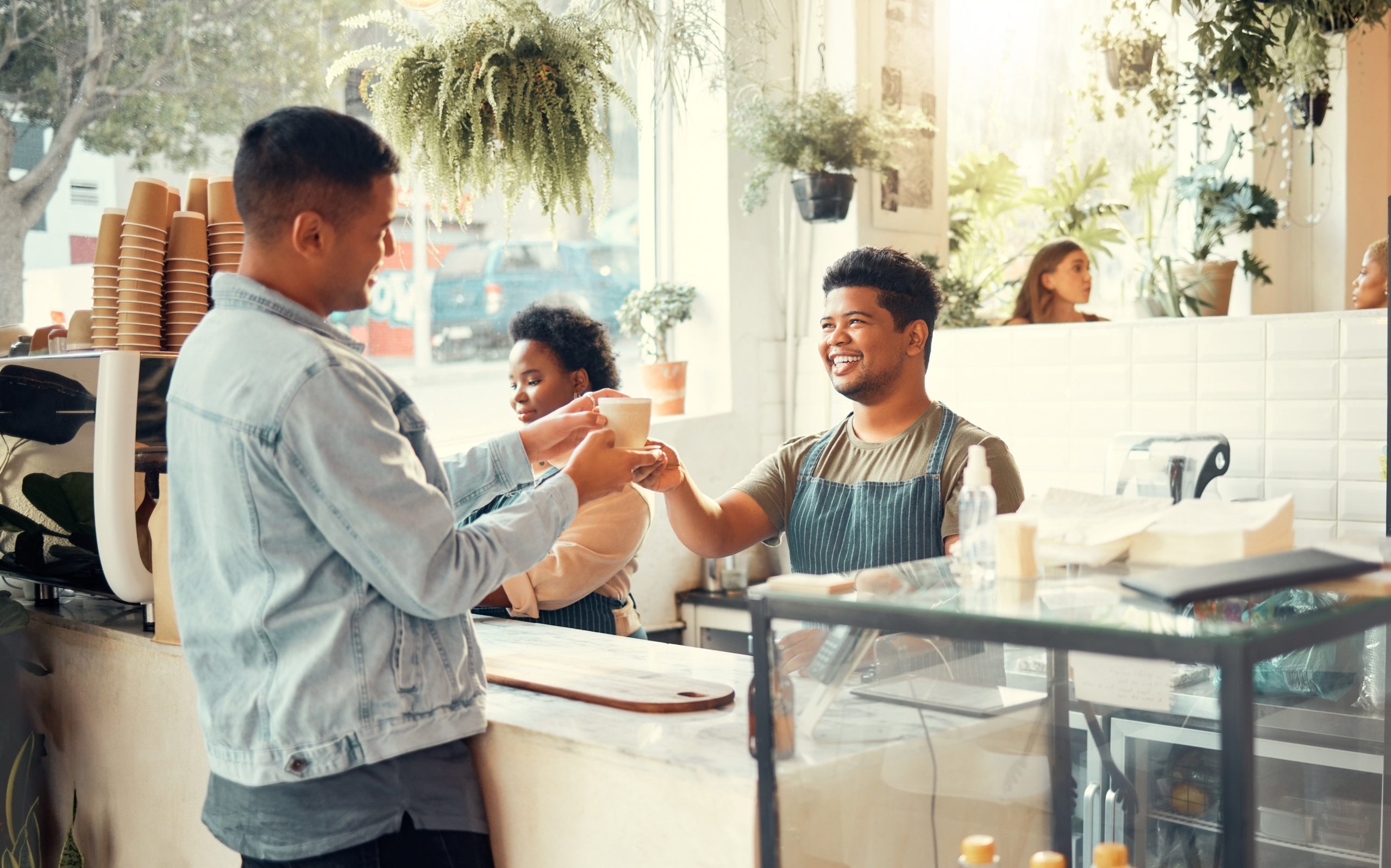 A barista serving coffee to a loyal customer in a coffee shop.